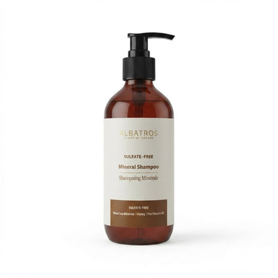 Albatros Sulfate-Free Mineral Shampoo in an amber brown bottle with a black pump dispenser and a cream-colored label.